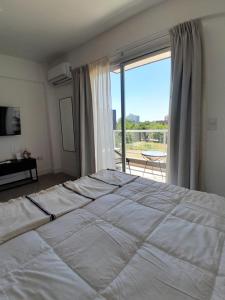 una camera con un grande letto e una grande finestra di Elegancia y Confort G&A Rent (308) a Ezeiza