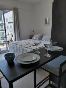 Una habitación con una mesa con dos vasos y una cama en Elegancia y Confort G&A Rent (308) en Ezeiza