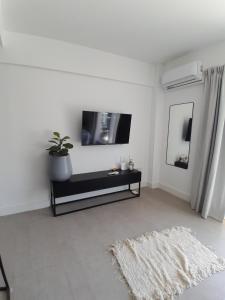 sala de estar con TV de pantalla plana en la pared en Elegancia y Confort G&A Rent (308) en Ezeiza