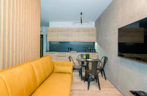 a living room with a yellow couch and a table at MTP/ZOO Prestige Apartments in Poznań