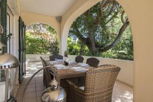 un patio con mesa y sillas en un porche en Villa Caravela, en Almancil