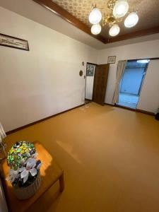 uma sala de estar vazia com uma mesa e uma janela em AnNam Stay Osaka em Osaka