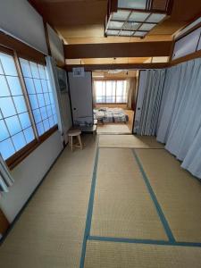 um quarto vazio com um quarto com uma cama e janelas em AnNam Stay Osaka em Osaka