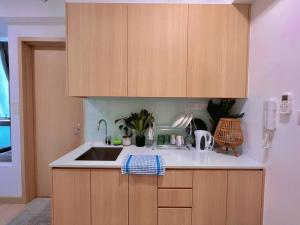 Comfy & Cozy Suites 3PX @ Colony, Near Monorail & Quill City Mall في كوالالمبور: مطبخ مع حوض ودواليب خشبية