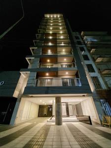 een hoog gebouw met een zuil ervoor bij Moderno 2amb con cochera in Mar del Plata