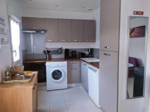 a kitchen with a washing machine and a washer at Maison Cosy à proximité de la Plage in Hermanville-sur-Mer