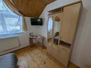 una camera da letto con un grande mobile in legno con specchio di Oskolok Dovbusha Mini-Hotel a Jaremče