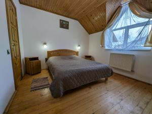 una camera da letto con un letto e una grande finestra di Oskolok Dovbusha Mini-Hotel a Jaremče