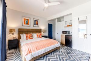ロードタウンにあるSebastian's on the beach hotelのベッドルーム1室(オレンジ色の枕が付いたベッド1台付)