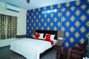 ein Schlafzimmer mit einem Bett mit einer blauen und goldenen Wand in der Unterkunft LEE PARADISE INN in Bangalore