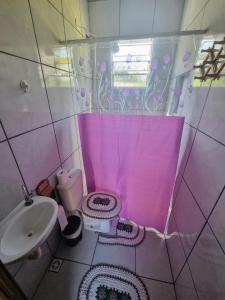 Baño de color rosa con aseo y lavamanos en Pousada_tres_amores en Itariri