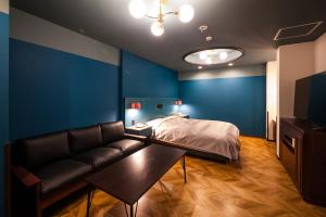 salon z kanapą i łóżkiem w obiekcie Hotel Torni ホテル トルニ w mieście Toyama