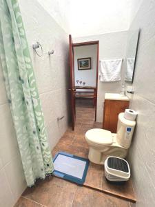 a bathroom with a toilet and a shower with a scale at Orquideas 3 in Jericó