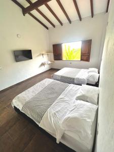two beds in a bedroom with a window at Orquideas 3 in Jericó