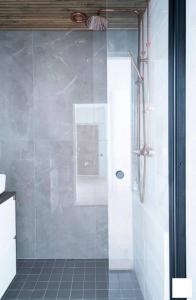 a shower with a glass door in a bathroom at Moderni kaksio ydinkeskustassa in Kuopio