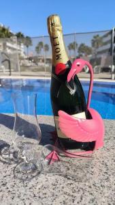 una botella de vino en una mesa junto a una copa en El Rincon Getaway Sea & Golf en Playa Flamenca