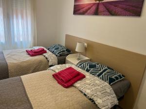duas camas num quarto de hotel com toalhas vermelhas em El Rincon Getaway Sea & Golf em Playa Flamenca