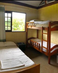 1 dormitorio con 2 literas y ventana en Chalé Azul, en Tamandaré