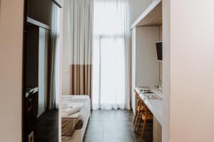 um quarto de hotel com uma cama e uma janela em Terrae Hydrunti em Lecce