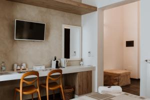uma cozinha com duas cadeiras e um balcão com uma televisão na parede em Terrae Hydrunti em Lecce