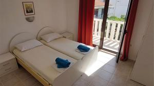 ein kleines Schlafzimmer mit 2 Betten und einem Balkon in der Unterkunft Pansion Palme in Drvenik
