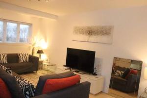 a living room with a couch and a television at Snug 2BR Apt. Free Parking, 4KTV in London