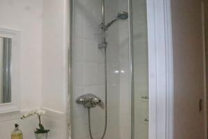 a shower with a shower head in a bathroom at Snug 2BR Apt. Free Parking, 4KTV in London