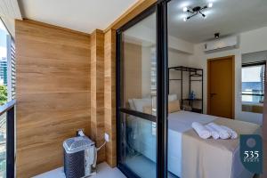 Cette chambre dispose d'un lit et d'une paroi en verre. dans l'établissement Mar & Conforto: Seu lar em Salvador, à Salvador