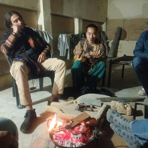 Ideal Guest House في جيلسامر: مجموعة من الرجال يجلسون حول النار