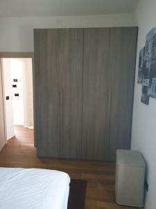 1 dormitorio con armario de madera y cama blanca en Il Pennino - Villa Penna, en Bolonia