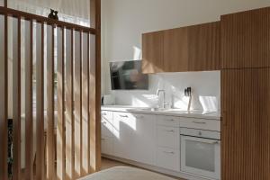 a kitchen with white cabinets and a sink at Comfort Stay - Old Town in Klaipėda +27 photos