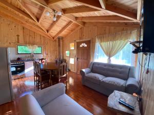 a living room with a couch and a table at Cabaña Llonquén in Liquiñe