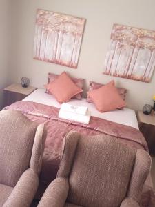 a bedroom with a bed with two chairs at TALITHA'S SELF-CATERING ACCOMONDATION in Walvis Bay