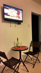 una mesa con dos copas de vino y una TV en la pared en DON ALEJANDRO en Trujillo
