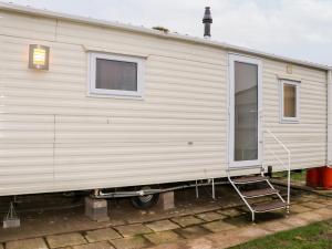 a white trailer is parked in a yard at 24 Winchelsea Sands Holiday Park in Winchelsea