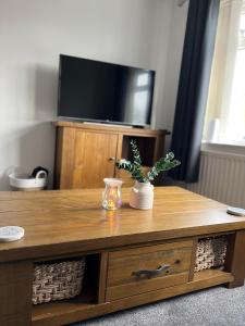 a wooden coffee table with a tv on top at Sunset Cottage in Stockton-on-Tees