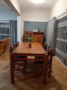 a dining room with a wooden table and chairs at Britsies @ Sea in Mossel Bay