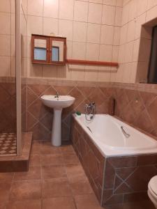a bathroom with a tub and a sink and a toilet at Britsies @ Sea in Mossel Bay