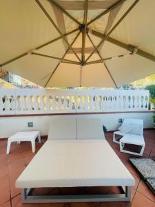 une table et des chaises blanches sous un grand parasol dans l'établissement Ti racconto il mare, à Salerne