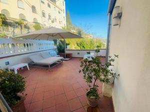 patio con sombrilla y bancos en el balcón en Ti racconto il mare, en Salerno