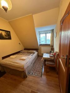 Dormitorio pequeño con cama y mesa en Pokoje Gościnne Złota Palma, en Lądek-Zdrój