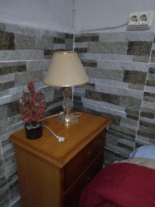 eine Lampe auf einer Kommode neben einer Ziegelmauer in der Unterkunft Habitación natural rústica in Cartagena