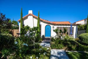 una pequeña casa blanca con una puerta azul en Long Beach Home Beautiful Private area, en Long Beach