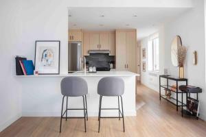 una cocina con 2 taburetes y una barra en Brooklyn bridge view residence en Nueva York