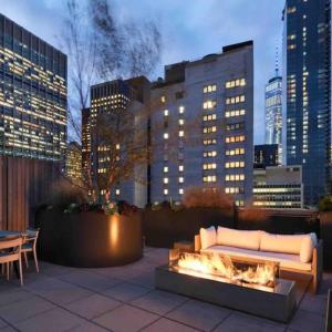 a couch sitting on a patio with a fire place at Brooklyn bridge view residence in New York