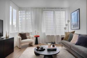 uma sala de estar com um sofá, uma cadeira e uma mesa em Brooklyn bridge view residence em Nova York