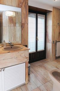 a large bathroom with a sink and a toilet at Apartamento Turistico la Solana in Baños de Río Tobía