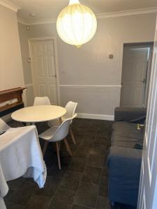 a room with a table and a bed and a table and chairs at Party house in Derby
