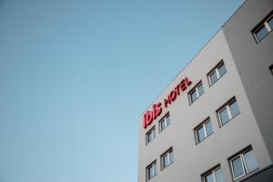 a white building with a red sign on it at ibis Presidente Prudente Manoel Goulart in Presidente Prudente