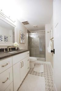 a white bathroom with a shower and a toilet at 5 KING BEDS, 1Q 1Full P/O NEWLY REMODELED 2800 sq ft in Knoxville